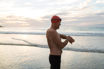 Senior man preparing to swim in the sea at dawn