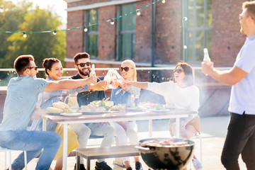 leisure and people concept - happy friends toasting non alcoholic drinks at bbq party on rooftop in summer