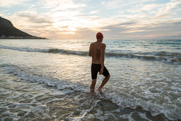 Fototapeta na wymiar Senior man preparing to swim in the sea at dawn