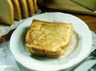 Sandwich con pan de molde tostado, jamón hervido y queso fundido.