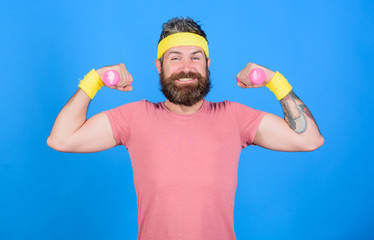 Athlete training with little dumbbell. Man bearded athlete exercising dumbbell. Motivated athlete...