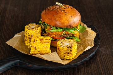 Delicious cheeseburger with corn on the black pan