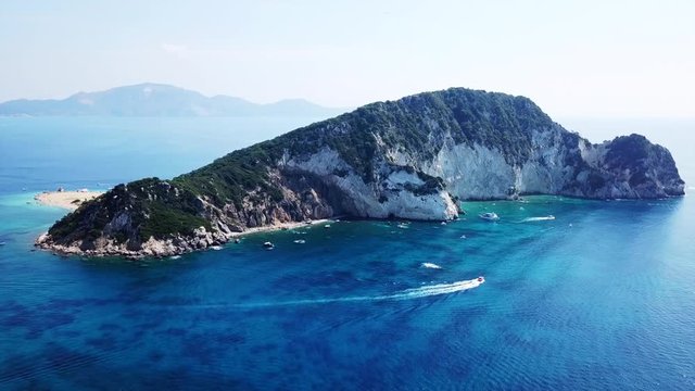 Aerial drone video from famous for Caretta caretta sea turtle haching, exotic small island of Marathonisi with white caves and sapphire sea and sandy beach , Zakynthos island, Ionian, Greece