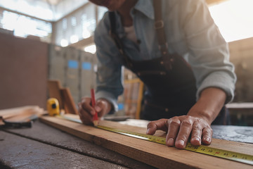 Carpenter working with equipment on wooden table in carpentry shop. woman works in a carpentry shop.