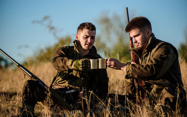 Hunters friends enjoy leisure. Hunters satisfied with catch drink warming beverage. Rest for real...