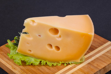 Maasdam cheese  in the board served salad leaves
