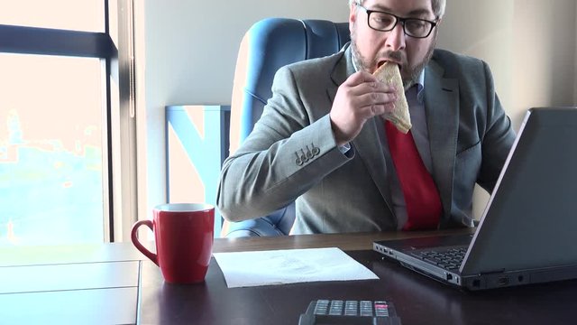 Busy manager working quickly at office and eating sandwich, stressful lifestyle, non stop. Active caucasian man typing on computer without lunch break, work hard under pressure to meet the deadline
