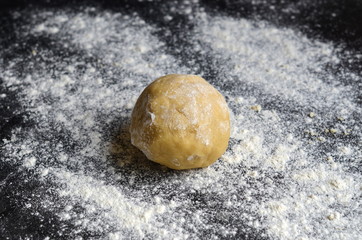 Ball of dough on dark floured surface