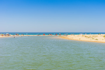 Many people relaxing on Salgados Beach, Algarve, Portugal