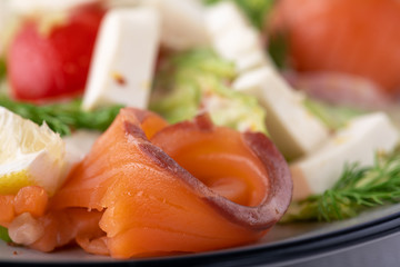 salad with salmon, cheese and vegetables. close up