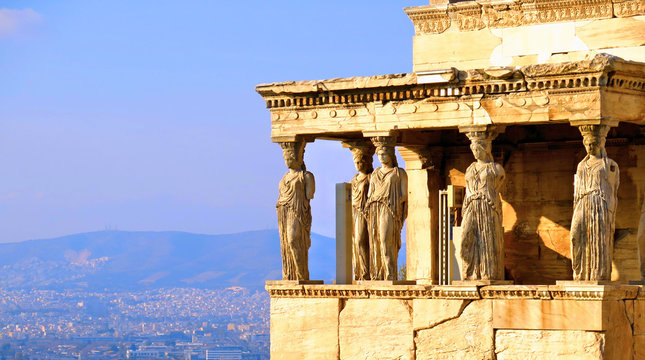 Athens Acropolis, Detail of Erectheion temple with caryatids and panoramic view of the Athens in background, Greece        