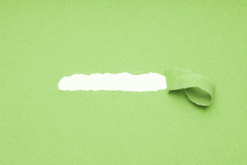 hole torn in green paper background shred to reveal hidden copy space underneath