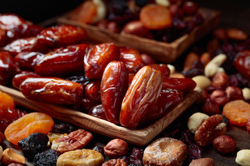 Various dried fruits and nuts in wooden dish.