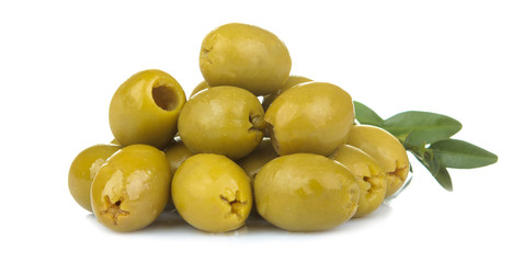 Green olives in a heap with leaves close up on a white isolated background