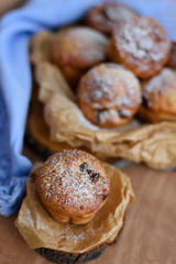 Cupcakes with raisins and candied fruits on a wooden background with a blue napkin with a blurred background.