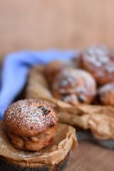Cupcakes with raisins and candied fruits on a wooden background with a blue napkin with a blurred background.