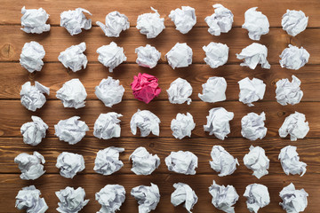 Concept of creativity and inspiration presented by many white paperballs and one color