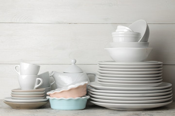 a lot of different dishes. Dinnerware. on a light concrete background. dishes for serving the table. various plates, bowls, and cups.