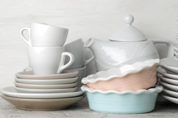 a lot of different dishes. Dinnerware. on a light concrete background. dishes for serving the table. various plates, bowls, and cups.