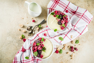 Two bowl with Semolina porridge with fresh berries, beige stone table copy space top view
