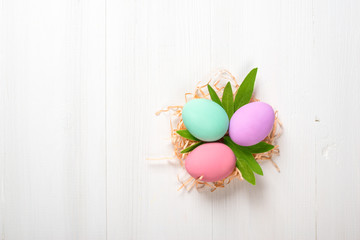 painted Easter eggs lie on a white wooden background, a card for Easter