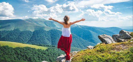 Young woman on the top of mountain