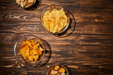top view of party snacks in bows on wooden table