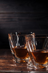 close-up view of two glasses of whisky on dark wooden table