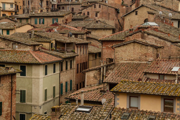 Fototapeta na wymiar Medieval brown houses with tile roofs in Siena, Tuscany, Italy. House pattern