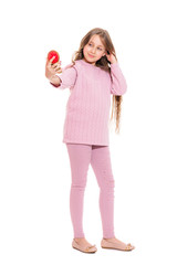 A smiling girl of about eleven with long hair attentively examines herself in the mirror