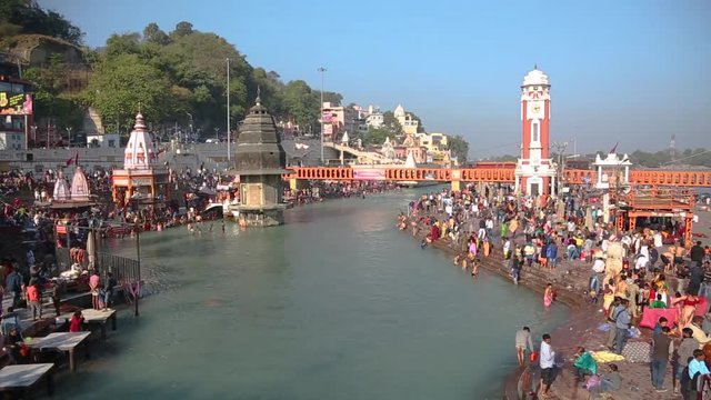 Holy ghats and temples at Haridwar, Uttarakhand India, sacred town for Hindu religion. Pilgrims praying and bathing(taking a holy dip) in the Ganges River.Haridwar Clocktower