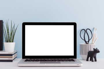 Stylish desk with laptop mock up. Minimal workspace desk with bright blue wall.