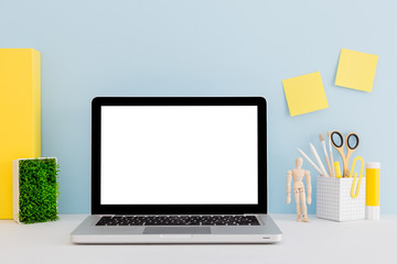 Mock up laptop, notebook on young student desk against blue wall. Back to school mock up.