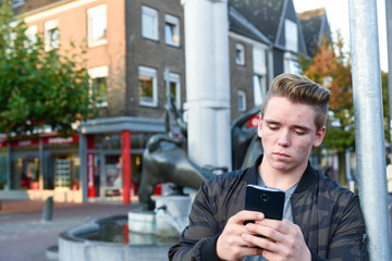 Jugendlicher mit Smartphone in der Stadt