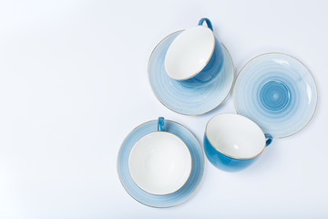 Clean dishes, coffee or tea set. Plenty of elegant porcelain cups and saucers at white background