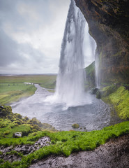 View from a small cave behind famous Seljalandsfoss waterfall in Iceland