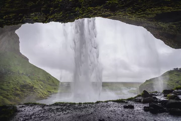 Fototapeten Blick von einer kleinen Höhle hinter dem berühmten Wasserfall Seljalandsfoss in Island © Fotokon
