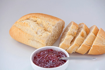  White bread and strawberry jam on a white background.