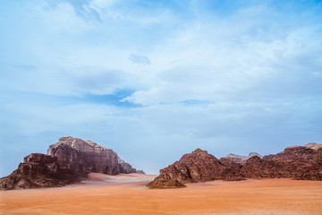 Fototapeta premium Red mountains of the canyon of Wadi Rum desert in Jordan. Wadi Rum also known as The Valley of the Moon is a valley cut into the sandstone and granite rock in southern Jordan to the east of Aqaba.