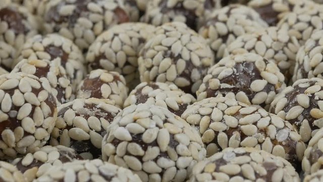 Heap of chocolate balls candies in sugar glaze. Candy peanuts with sesame seeds