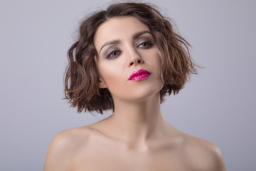 Portrait of a beautiful woman with short wavy hair and bright lips.