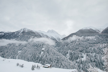 Fototapeta na wymiar Lonely mountain shelter in snowcapped mountains