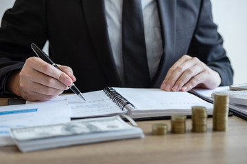 Businessman accountant counting money and making notes at report doing finances and calculate about cost of investment and analyzing financial data, Financing Accounting Banking Concept