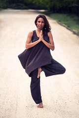 attractive woman practicing yoga in park