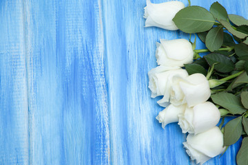 Obraz na płótnie Canvas White Rose. A bouquet of delicate roses on a wooden blue background. Place for text, close-up. Romantic background for spring holidays.