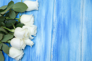 White Rose. A bouquet of delicate roses on a wooden blue background. Place for text, close-up. Romantic background for spring holidays.