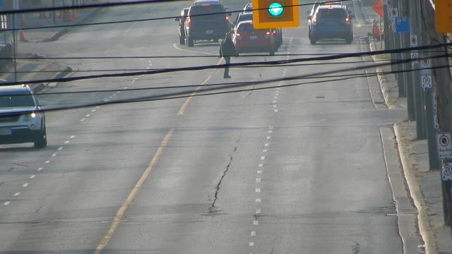 4K Guy J-Walking Across Street With Lots Of Traffic In Distance