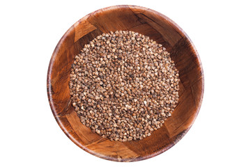 Brown buckwheat grain in wooden bowl isolated on white. Healthy food pattern background.