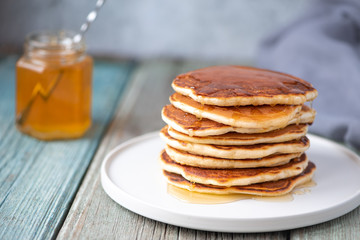 Sweet breakfast Pancakes with honey on a plate.