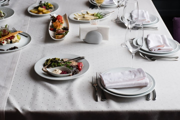 Served for banquet restaurant table with dishes, snack, cutlery, wine and water glasses, european food, selective focus